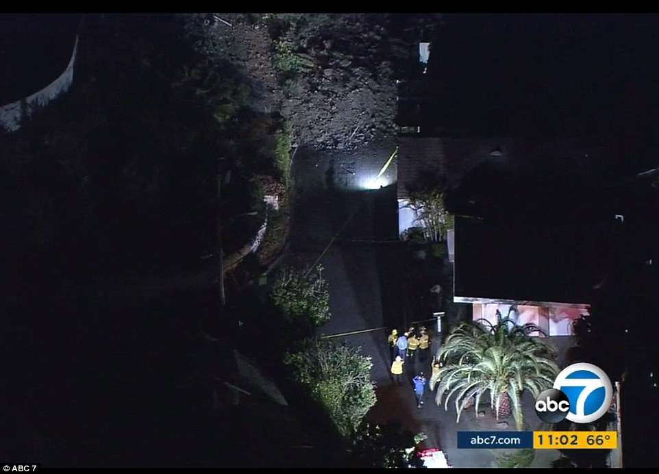 Mud and debris (top center) buried two power poles and took down power lines, leaving about 422 residents without power, the Los Angeles Department of Water and Power said. The Los Angeles Fire Department (pictured) said an estimated 20 tons of earth came fell down the hill