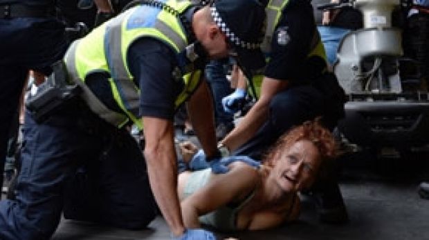 Police arrest a woman outside Flinders Street Station on Wednesday.