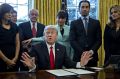 Stand up: US President Donald Trump speaks before signing another executive order cutting federal regulations while ...