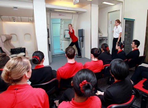 Aircrew for Emirates shown how to operate an aircraft emergency door, during a training session at the Emirates Aviation ...