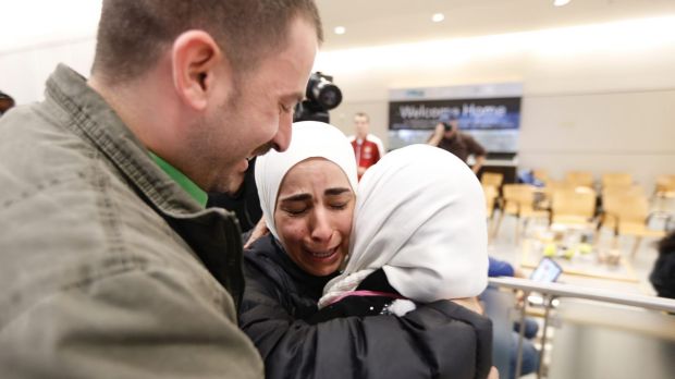 Hisham, left, and Mariam Yasin, centre, welcome their mother Najah al-Shamieh, from Syria, after immigration authorities ...