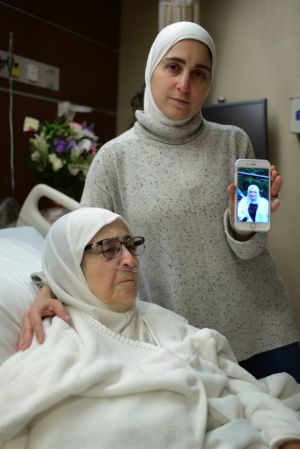 Nour Ulayyet holds her smartphone with a photo of her sister Sahar al-Gonaimi, who was not permitted to enter the United ...