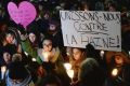 People attend a vigil in Montreal for victims of Sunday's shooting at a Quebec City mosque. Sign reads "let's unite ...