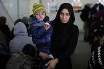 A Syrian boy eats bread as waits in line with his mother as hundred of Syrian families wait to register at the United Nations High Commissioner for Refugees headquarters, in Beirut, Lebanon, Monday, Jan. 30, 2017. By executive order, U.S. President Donald Trump imposed a 90-day ban, Friday, that affects travel to the U.S. by citizens of Iraq, Syria, Iran, Sudan, Libya, Somalia and Yemen and puts an indefinite hold on a program resettling Syrian refugees.