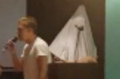 Two men dressed in white hoods and white linen interrupted the Young Liberal council meeting in Sydney.