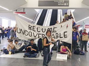 Demonstrators block an escalator at the international terminal as protests against President Donald Trump's executive order banning travel from seven Muslim-majority countries continue at San Francisco International Airport, Sunday, Jan. 29, 2017.