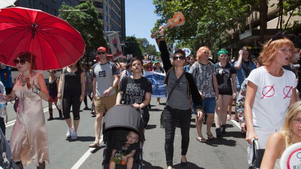 Amanda Palmer joins marchers in Sydney, holding her ukulele aloft.