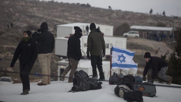 Settlers stand on the roofs of the Amona outpost, where 330 settlers have made their homes in defiance of Israeli and ...