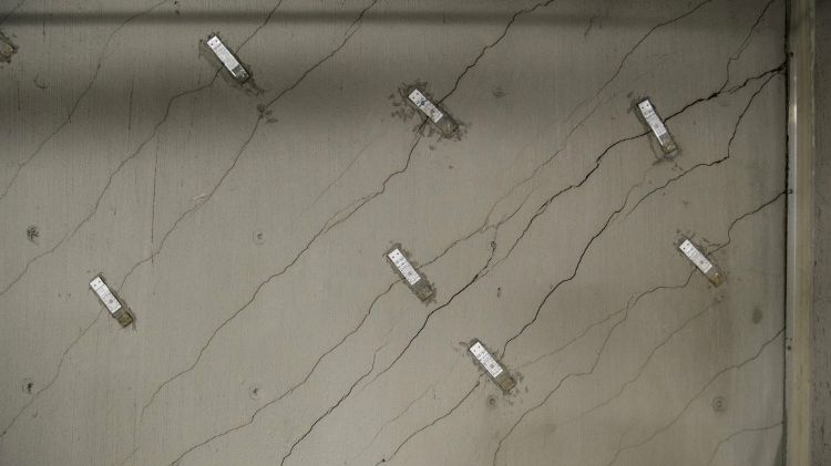 Stress gauges sit on a wall with floor-to-ceiling cracks in the storage area.