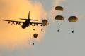 A Royal Australian Air Force C-130H Hercules from No 37 Squadron simultaneously drops commandos from the 2nd Commando ...