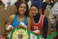Aliyah Charbonier (L) presenting Amaiya Zafar (R) with the belt she was awarded after Zafar was disqualified from their ...