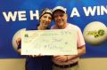 Gina Short brandishes her lottery cheque with her husband Len.