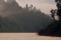 A river flows through Gunung Mulu National Park as a mountain looms in the distance. Sarawak, Malaysia. 