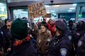 Protesters are surrounded by police officers at John F. Kennedy International Airport in New York.