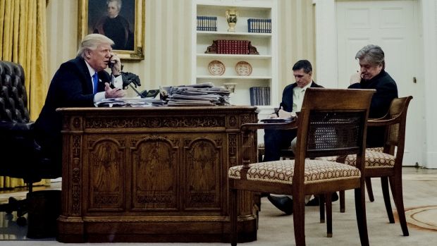 Mr Trump's national security adviser Michael Flynn, middle, and chief strategist Steve Bannon listen in on the ...