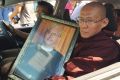 A Buddhist monk holds a portrait of Ko Ni on the way to his funeral.
