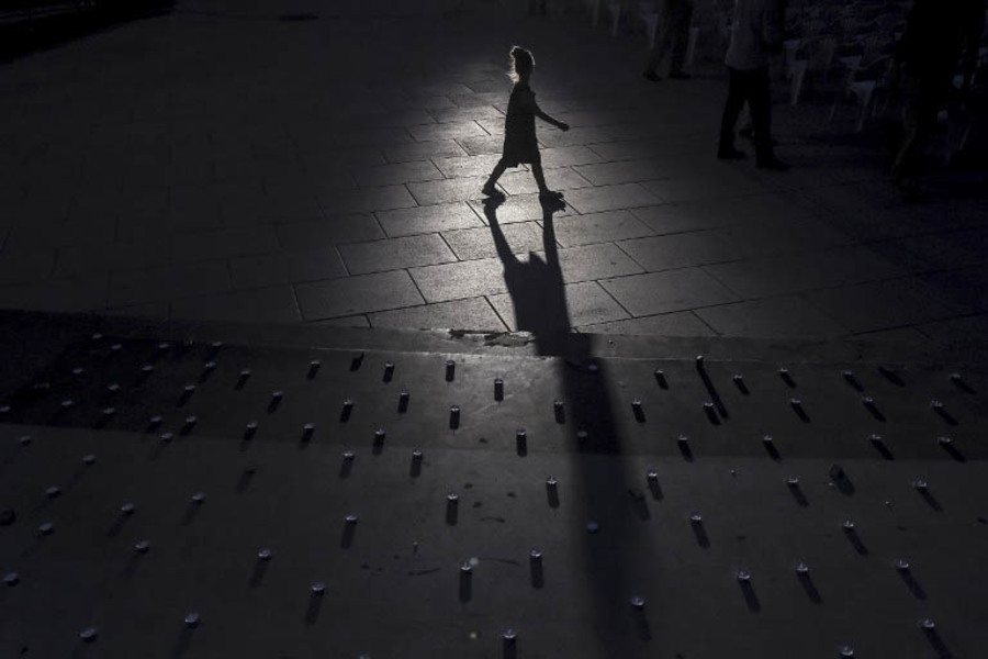 A  young girl walks past candles displayed in a vigil for the nine victims at the Olympia shopping centre in Munich, shot dead by an 18 year-old German-Iranian. (Armend Nimani, AFP Photo)