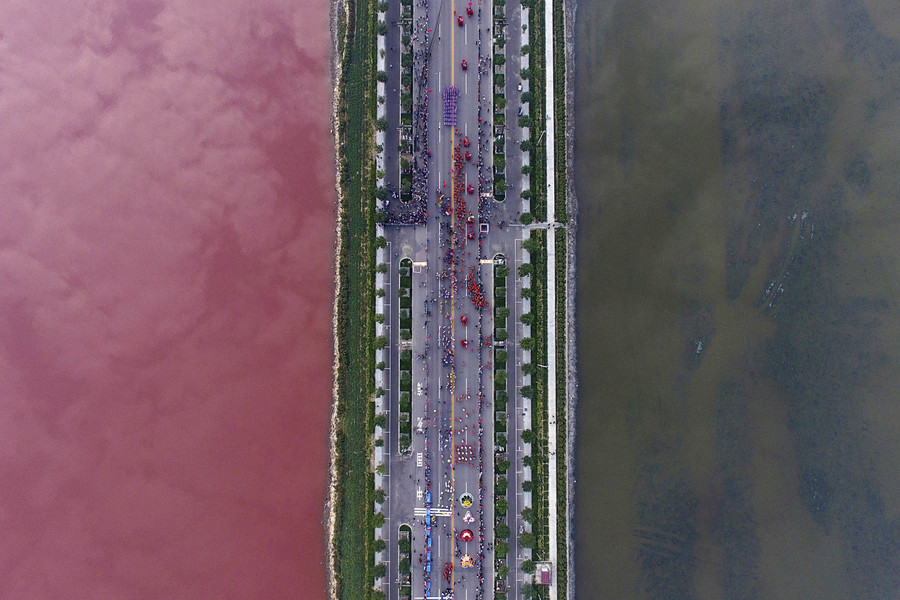 A salt lake which is separated by a road, shows parts of it in different colours due to algae, in Yuncheng, Shanxi Province, China, September 25, 2016. (Wei Liang/Reuters)