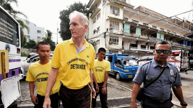 Peter Scully (second from left) arrives at the Cagayan De Oro court handcuffed to another inmate on the first day of his ...