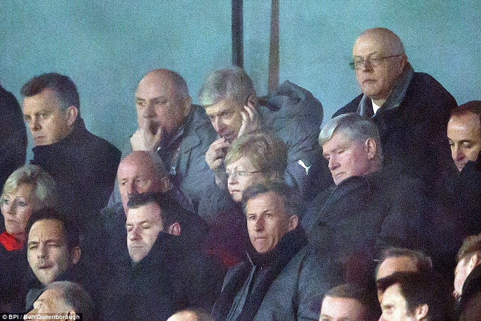 Arsene Wenger speaks into a microphone from the stands as he serves his touchline ban during Arsenal's defeat