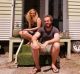 Ashleigh and Dan sit outside their tiny home.