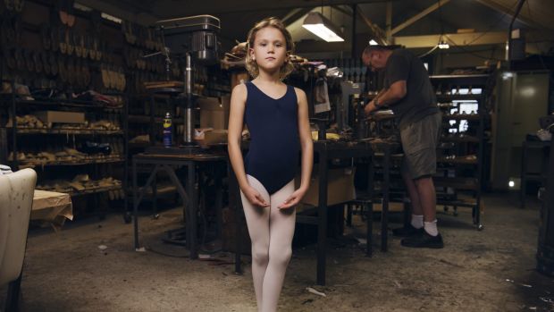 Eight-year-old Alexandra Shaw  in the factory behind Salvios Dancing Shoes, in Randwick, with Phil Salvio toiling in the ...