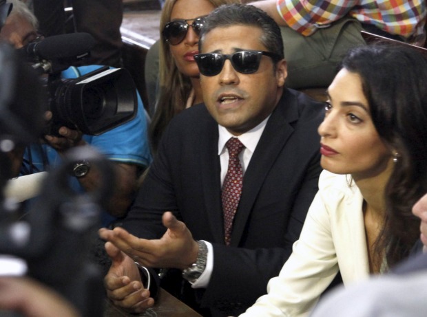 Al Jazeera television journalists Mohamed Fahmy, talks to the media, with his wife, Marwa Omara, left and lawyer Amal ...