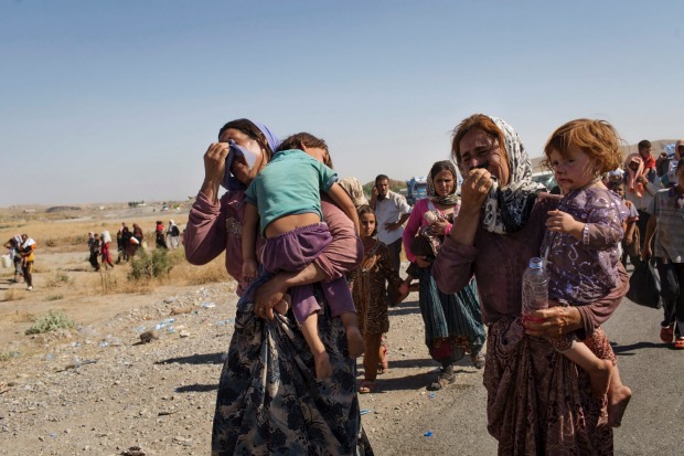 Iraqi Yazidi people who fled their homes in Sinjar, enter Iraq from Syria at a border crossing in Feshkhabour in Dohuk ...