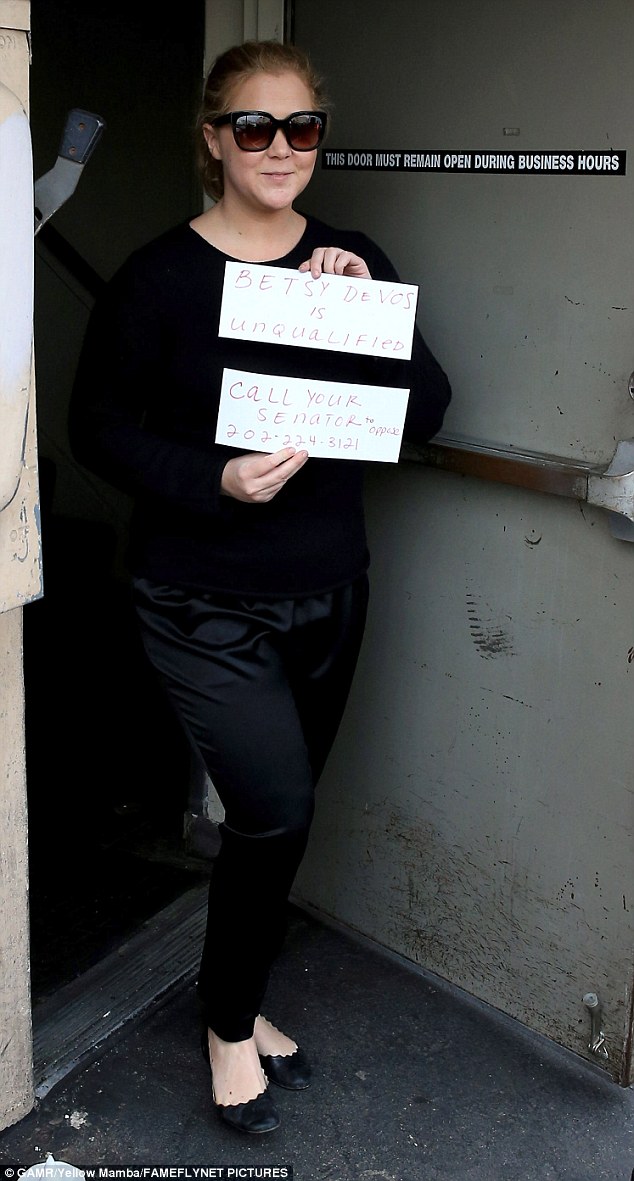 Upside of fame: The Trainwreck star clearly took advantage of the waiting paparazzi to get her message across as she left the eatery by a back door carrying her handmade signs