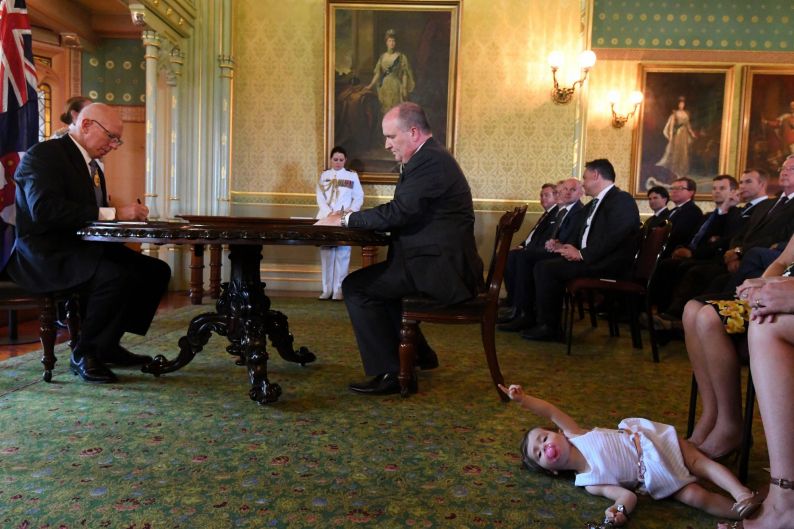 David Elliott, new Minister for Counter Terrorism, signs an oath at Government House as John Barilaro's daughter Sofia ...