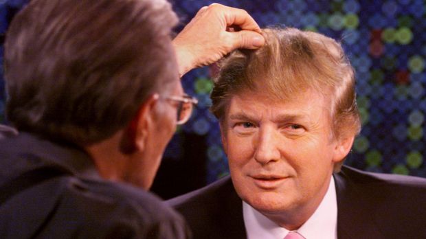 Talk show host Larry King examines Trump's hair in 2004.