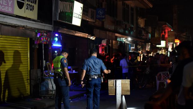 Police at the scene of a double shooting in the Manila suburb of Baclaran, where two masked gunmen shot dead two men ...