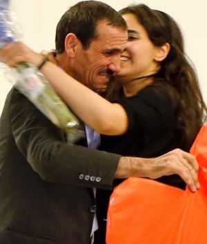 Ali Vayeghan, an Iranian citizen with a valid U.S. visa, left, is kissed by his niece Marjan Vayghan, as his brother ...