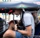 Two male passengers and a driver sit in a tuk-tuk in Bangkok, Thailand.