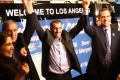 Ali Vayeghan, an Iranian citizen with a valid US visa, lifts his arms with his brother Houssein and Los Angeles mayor ...