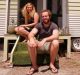 Ashleigh and Dan sit outside their tiny home.