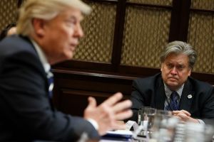White House Chief Strategist Steve Bannon listens at right as President Donald Trump speaks during a meeting on cyber ...
