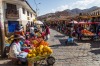 People selling and buying fruits at a market in the steets of Cusco, Peru.