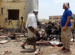 Fighters loyal to the government gather at the site of a suicide car bombing in Yemen’s southern city of Aden, Yemen, Monday, Aug. 29, 2016.