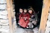 Inquisitive kids peering out of their doorway Nepal.