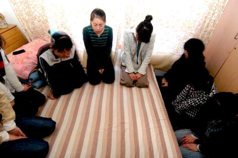 A group of women hold a prayer session at an underground house church in Beijing, 2008. (Getty Images)