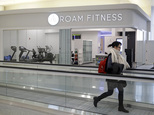 In this Jan. 30, 2017 photo, a traveler walks past the soon-to-be-open ROAM Fitness gym at Baltimore-Washington International Thurgood Marshall Airport in Linthicum, Md. Working out while waiting for your flight will soon be an option at BWI, where the only gym at a U.S. airport past security will open this week, with plans for 20 more at airports by 2020. (AP Photo/Patrick Semansky)