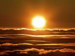 The sun rises over the clouds in front of the summit of Haleakala volcano in Haleakala National Park on Hawaii's island of Maui, Sunday, Jan. 22, 2017. Park officials say the sunrise on Haleakala attracts over a thousand people a day, resulting in an overload of visitors and creating a safety hazard. As a result, anyone wanting to see the sunrise on the summit will now be required to make reservations in advance and pay a small fee. (AP Photo/Caleb Jones)