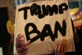 A man holds a placard during a gathering in Paris to protest US President Donald Trump's recent travel ban.