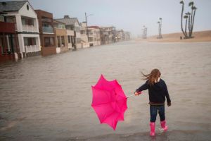 Isabella Busse , 6, walks through floodwater near the Seal Beach Pier during a storm in Seal Beach, Calif., Sunday, Jan. ...