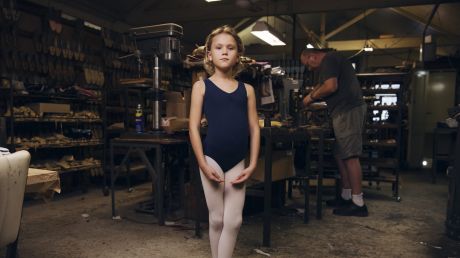 Eight-year-old Alexandra Shaw  in the factory behind Salvios Dancing Shoes, in Randwick, with Phil Salvio toiling in the ...
