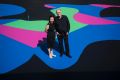 Architect and arts patron Corbett Lyon with his wife Yueji standing on Reko Rennie's <i>Visible Invisible</i>, painted ...