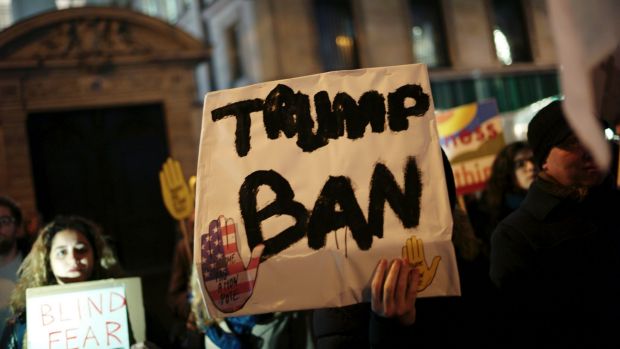 A man holds a placard during a gathering in Paris to protest US President Donald Trump's recent travel ban.