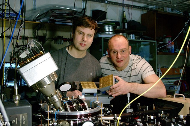 Professor Winfried Hensinger (right) and Lead author Dr Bjoern Lekitsch (left) with a quantum computer blueprint model behind a quantum computer prototype at the university. They are part of a team of researchers from around the world, including a team from Google, that have unveiled what they say is the first practical blueprint for the 'holy grail' of computing - a quantum computer.