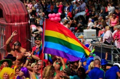 "Amsterdam, Netherlands- August 4, 2012: On the foreground participants of the gay canal parade. they holding the ...